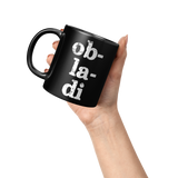 Ob_La_Di_Ob_La_Da_11_oz_Black_Coffee_Mug_Lifestyle_Raised_Hand_LH_Mockup.png_15559209
